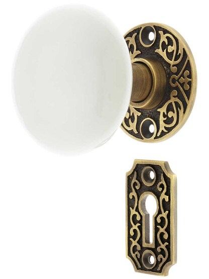 Scroll Rosette Mortise Lock Set with White Porcelain Door Knobs in Antique Brass.